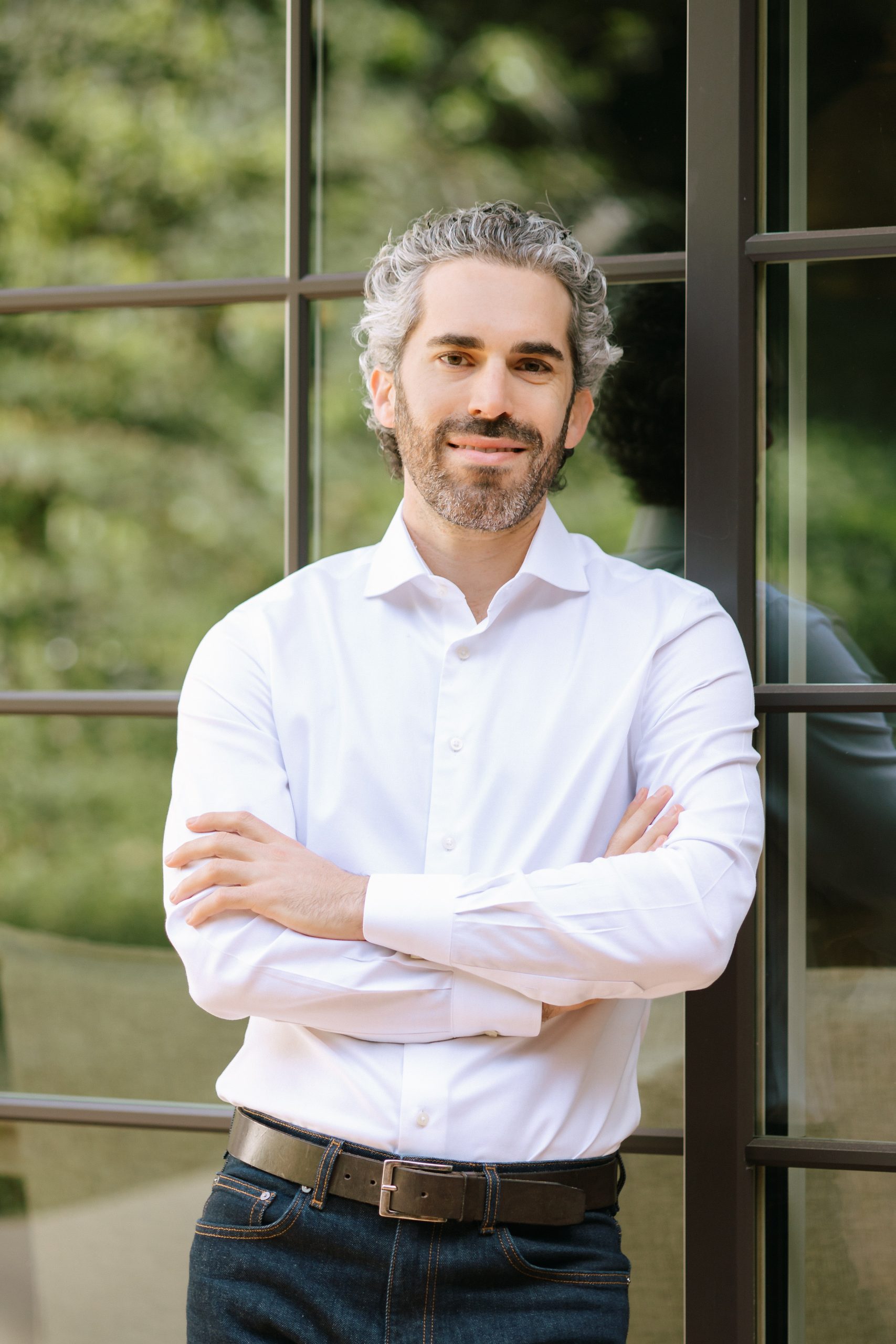 Real estate agent in white shirt standing in front of window paned door